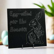 Granite tile with an engraving of Egg-cited for the Season,' and a bunny on the top left and bottom right corners respectively.