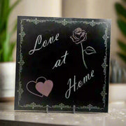 Granite tile with an engraving of 'love at home,' a rose and heart on opposite sides, all surrounded by an artistic border.