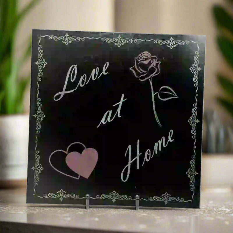 Granite tile with an engraving of 'love at home,' a rose and heart on opposite sides, all surrounded by an artistic border.