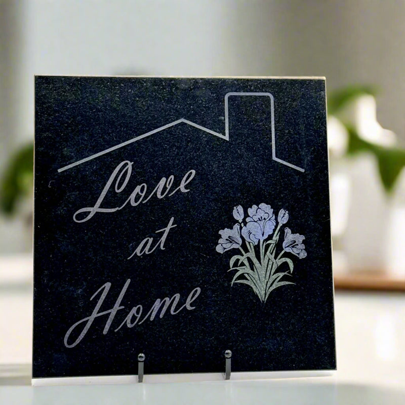 Granite tile with an engraving of 'love at home,' a bundle of tulips and iris flowers